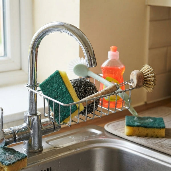 Cluttered kitchen sink area with a worn sponge and plastic soap bottle scattered on a marble countertop.